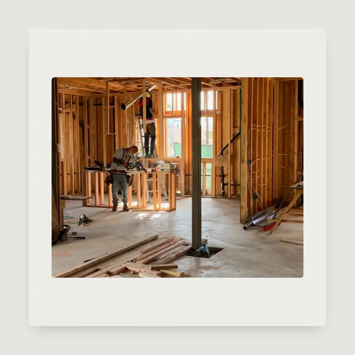A photo of carpenters working inside a timber frame